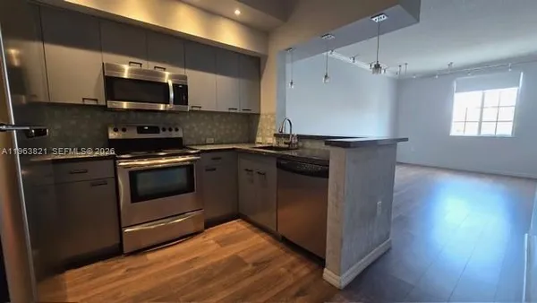 a kitchen with a stove a microwave and refrigerator