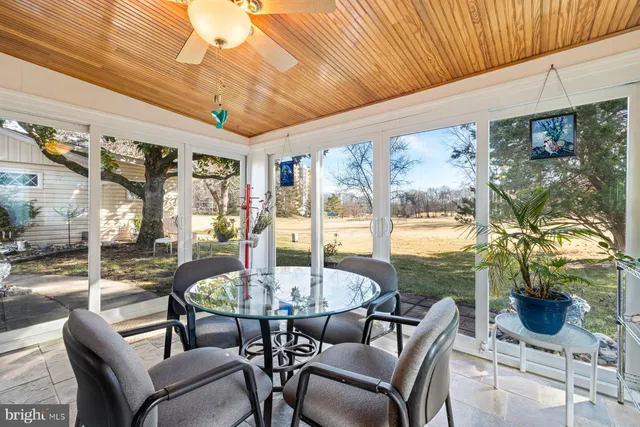 a dining room with furniture water view and a floor to ceiling window