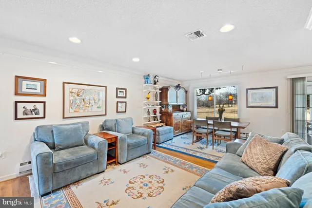 a living room with furniture kitchen view and a window