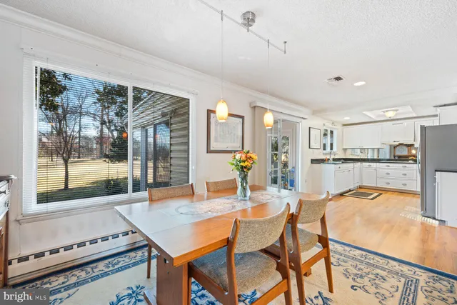 a dining room with furniture and a floor to ceiling window