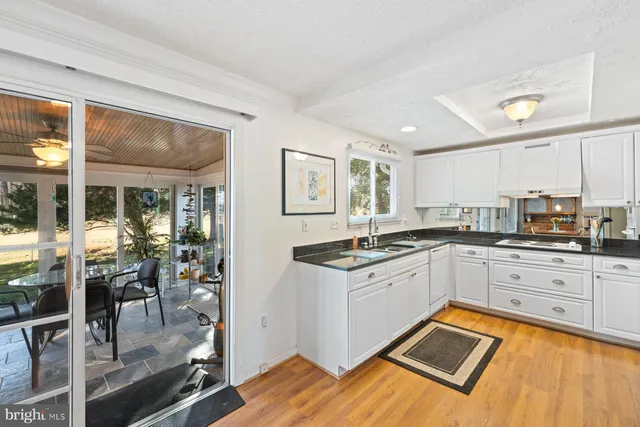 a kitchen with granite countertop a stove a sink and a refrigerator