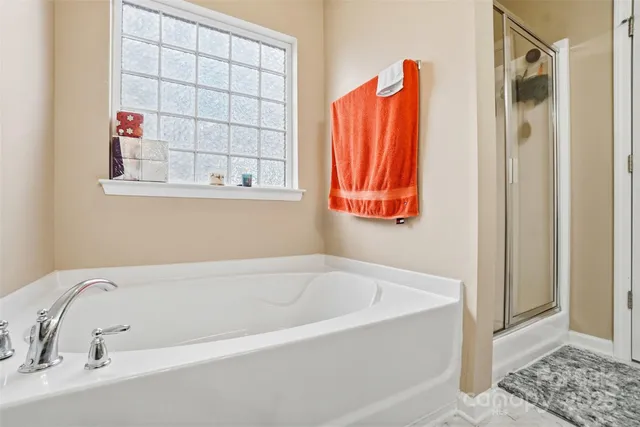 a white bath tub and shower sitting next to a window