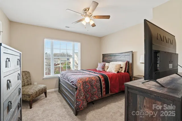 a bed room with a bed and a ceiling fan