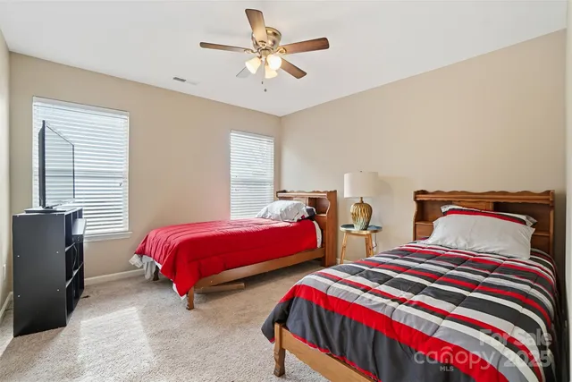 a bedroom with two beds and a chandelier