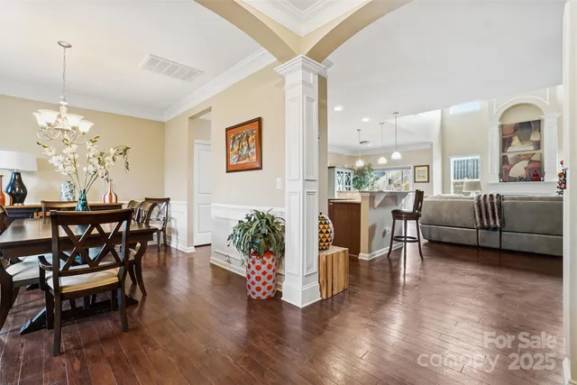 a dining room with furniture potted plants and wooden floor