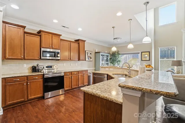 a kitchen with granite countertop a sink a counter space appliances and cabinets