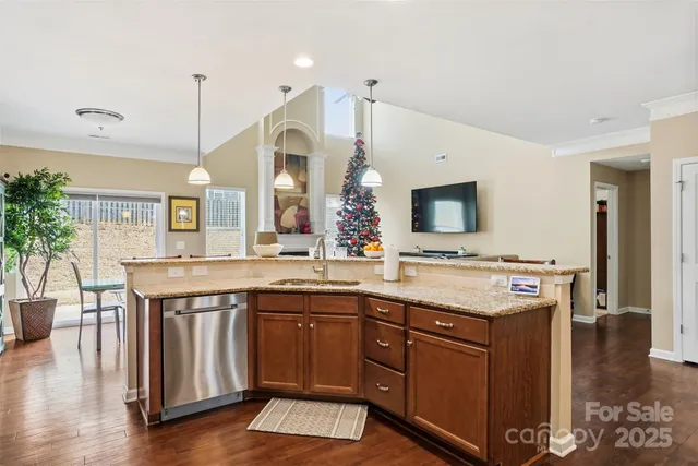 a kitchen with a sink and a stove with wooden floor