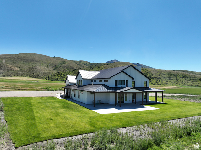 100 Whit Lane Georgetown, ID 83239 - Photo 70 of 76 Rear view of property with a metal roof, a mountain view, a yard, and a patio area