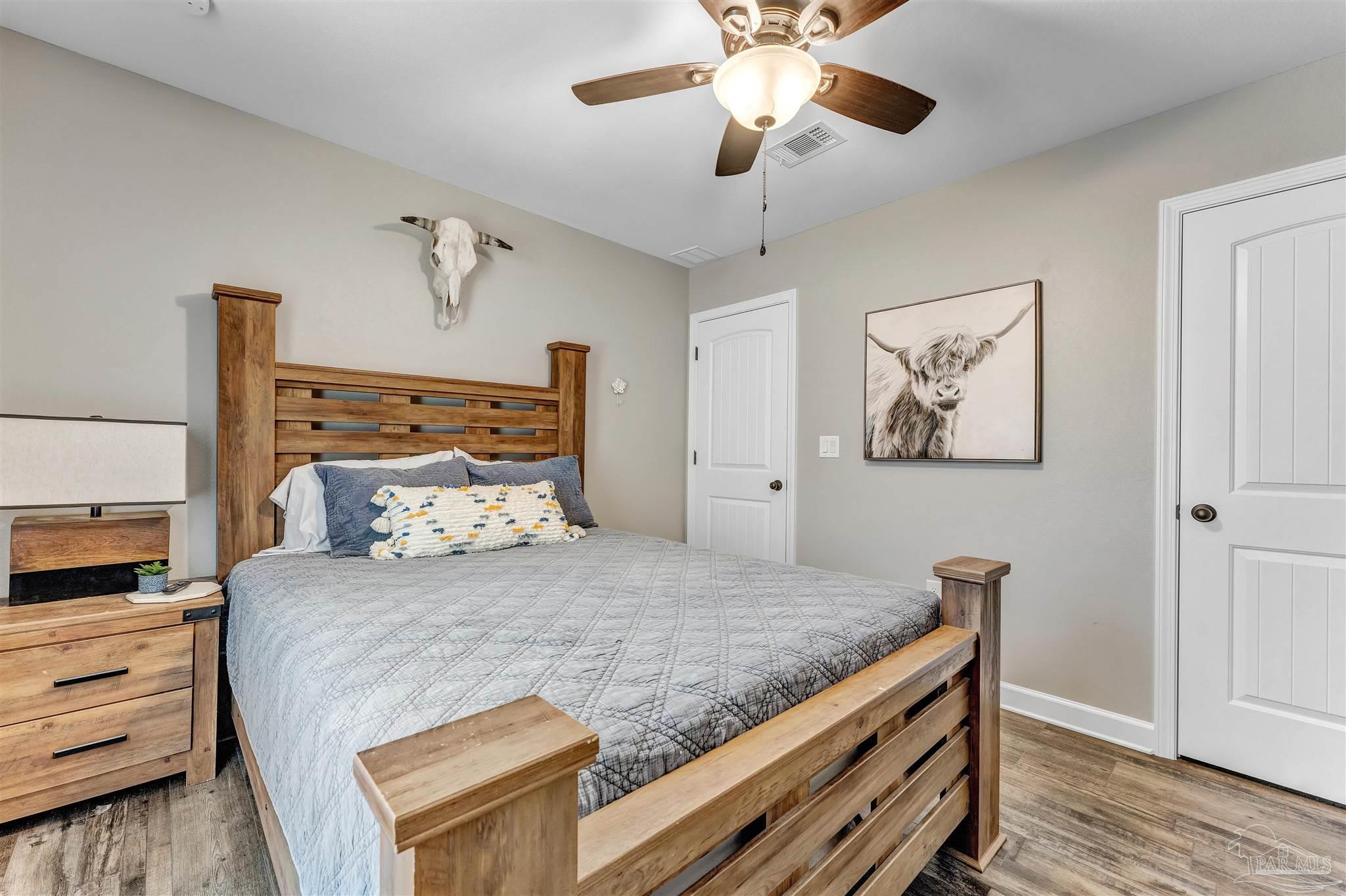 2548 10 Mile Road Milton, FL 32571 - Photo 22 of 37 a bedroom with a large bed and a chandelier