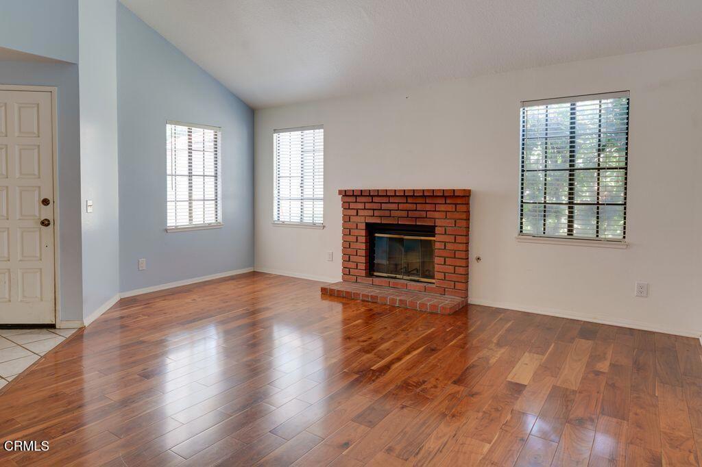 8541 Creekside Place Rancho Cucamonga, CA 91730 - Photo 7 of 18 an empty room with wooden floor fireplace and windows