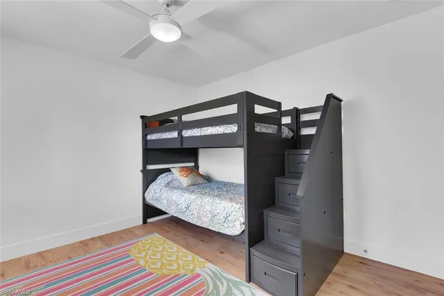 a bedroom with a bed and a chandelier fan