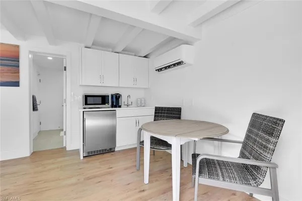 a kitchen with stainless steel appliances kitchen island granite countertop a table chairs and a refrigerator