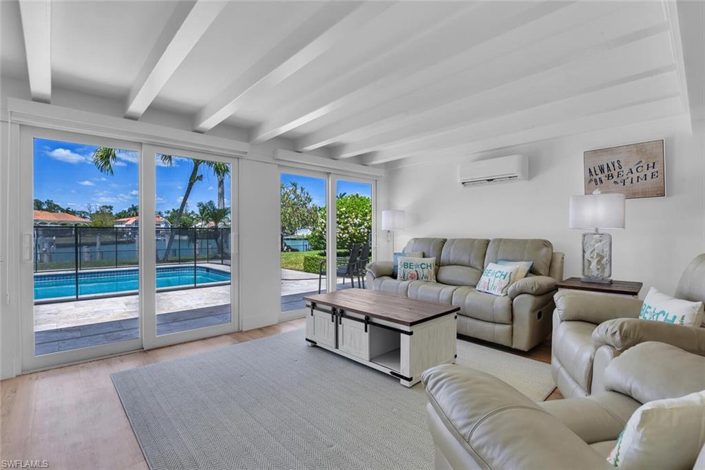 367 Mooring Line Drive Naples, FL 34102 - Photo 3 of 44 a living room with furniture and large windows