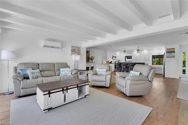 a living room with furniture and view of kitchen