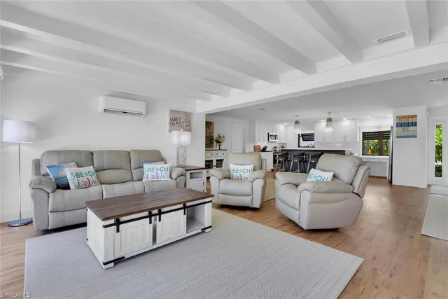 a living room with furniture and view of kitchen