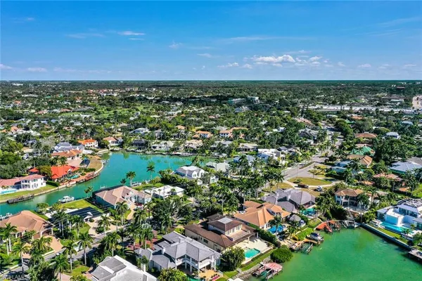 an aerial view of residential houses with outdoor space and trees