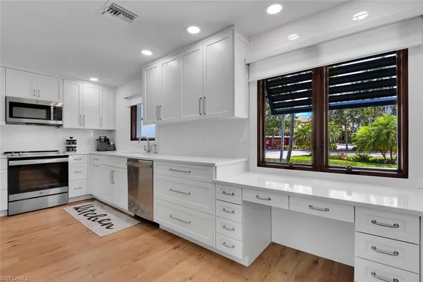 a kitchen with stainless steel appliances a stove sink and microwave