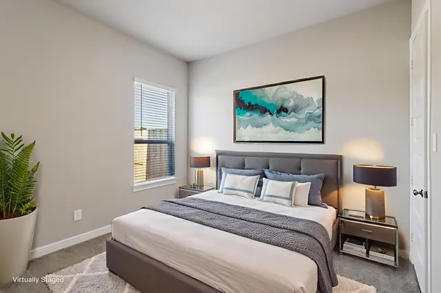 a bedroom with a bed and a painting on the wall