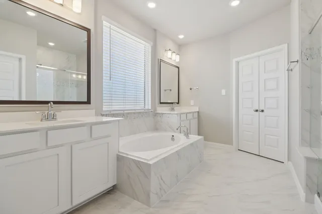 a bathroom with a tub a sink and mirror