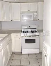 a kitchen with white cabinets and white appliances