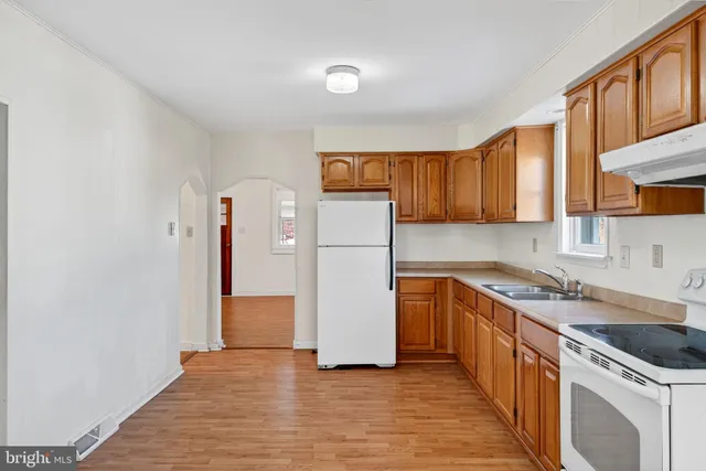 a kitchen with a sink a refrigerator and cabinets