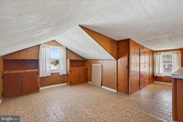 an empty room with windows and closet