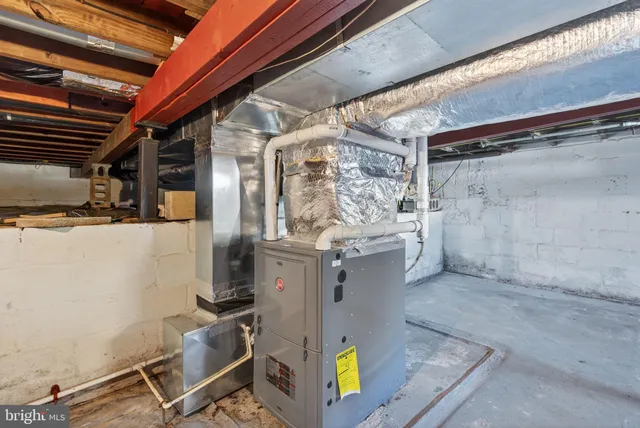 a room with water heater and wooden cabinets