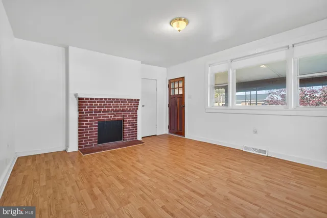 a view of an empty room with a fireplace and a window