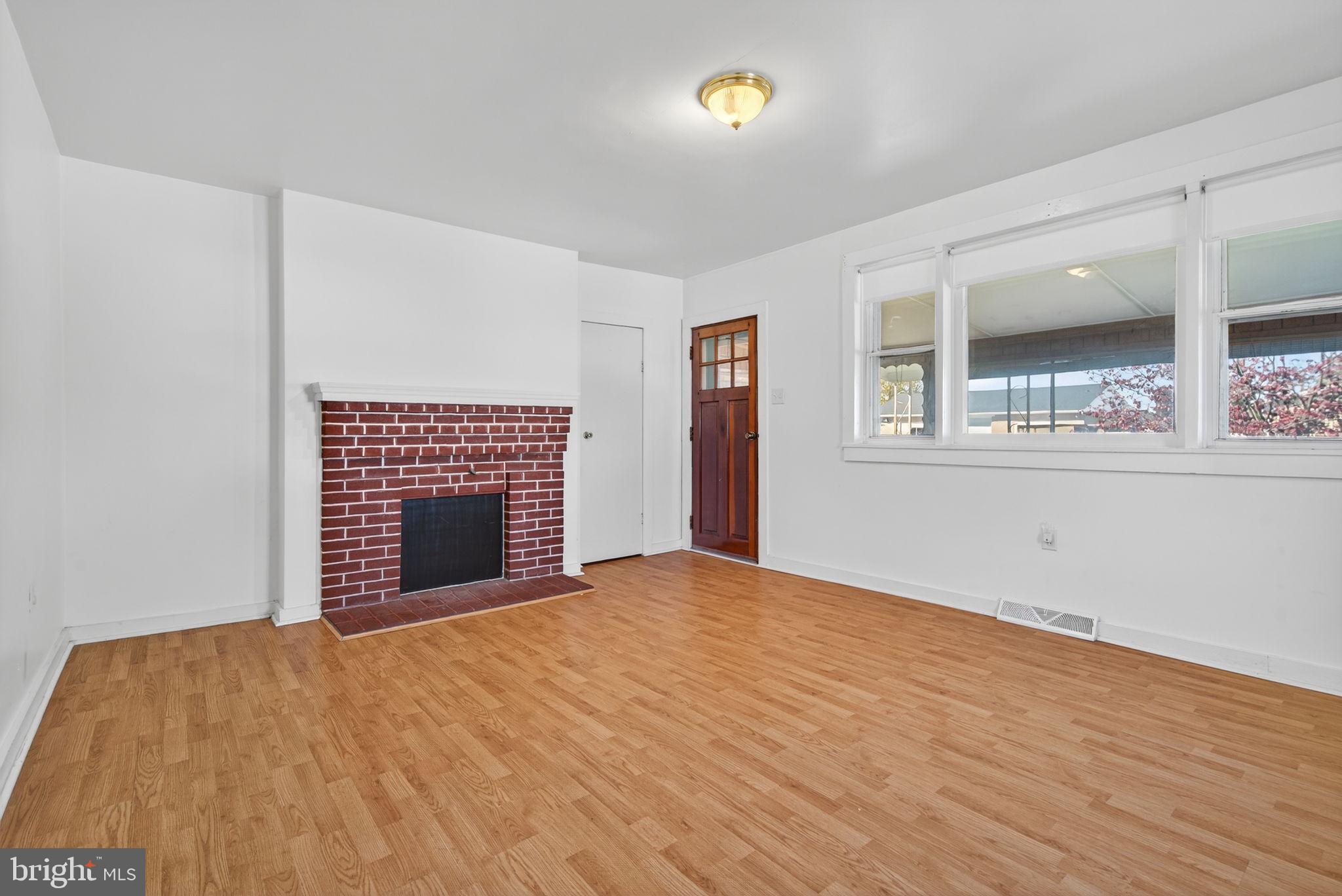 1705 Virginia Avenue Dover, PA 17315 - Photo 9 of 41 a view of an empty room with a fireplace and a window