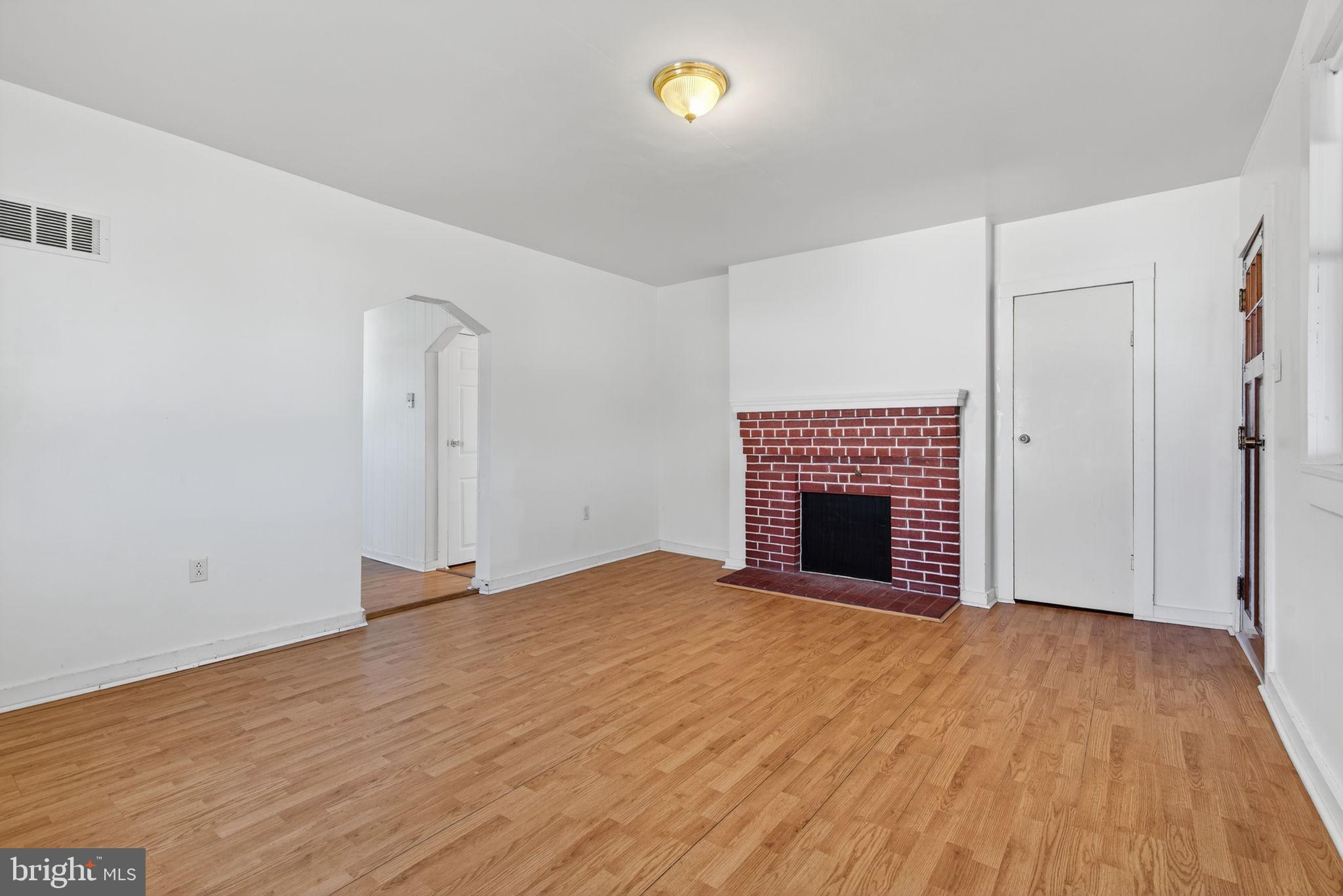 1705 Virginia Avenue Dover, PA 17315 - Photo 10 of 41 a view of an empty room with wooden floor and a fireplace