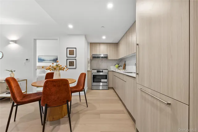 a kitchen with white cabinets and chairs