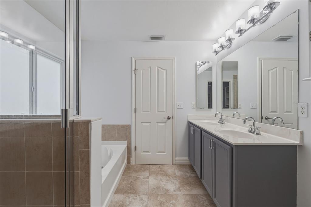 25134 Palisade Road Punta Gorda, FL 33983 - Photo 49 of 58 a en suite bathroom with a double vanity sink a mirror and a shower