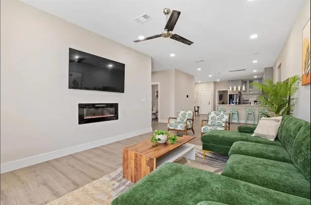 a kitchen with stainless steel appliances granite countertop a stove top oven a sink dishwasher a refrigerator and white cabinets with wooden floor