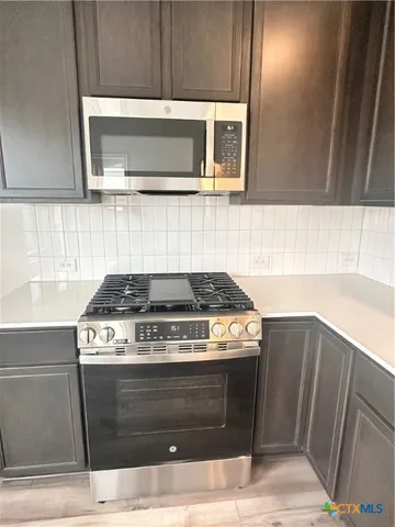 a stove top oven sitting inside of a kitchen