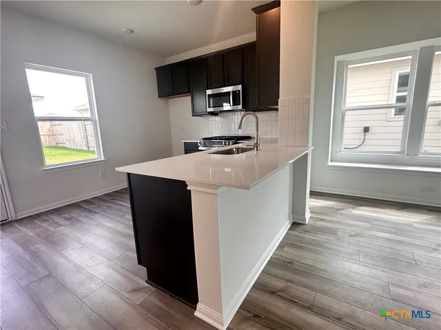 a kitchen with a stove a sink and a window