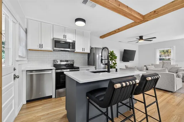 a kitchen with stainless steel appliances kitchen island granite countertop a sink and cabinets