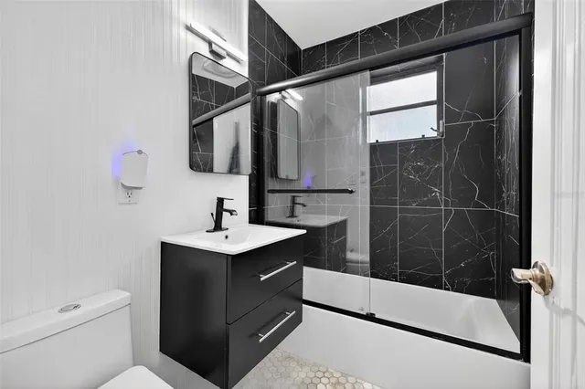 a bathroom with a sink a toilet a mirror and shower