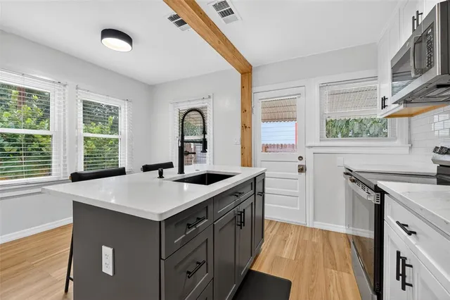 a kitchen that has a sink a stove and a window