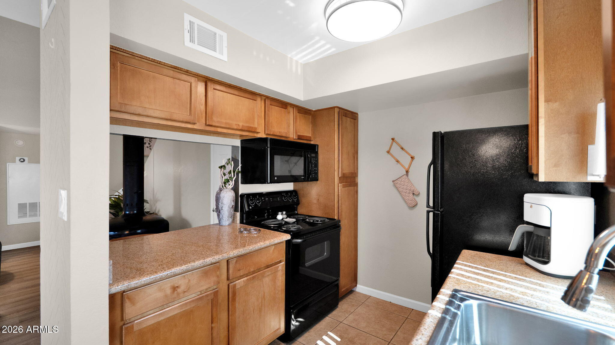 3500 North Hayden Road, Unit 1708 Scottsdale, AZ 85251 - Photo 15 of 25 a kitchen with a refrigerator and a stove top oven