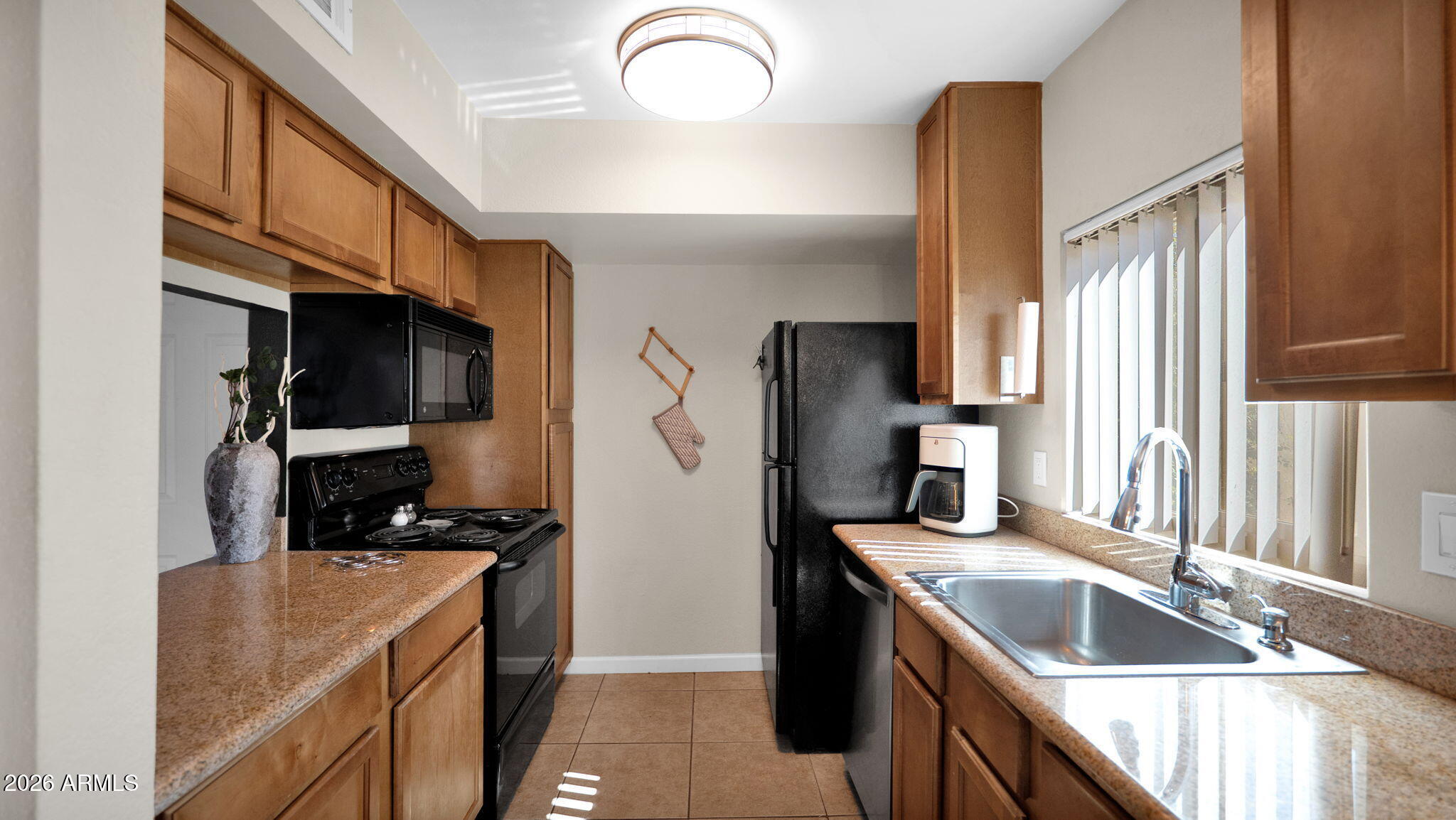 3500 North Hayden Road, Unit 1708 Scottsdale, AZ 85251 - Photo 17 of 25 a kitchen with granite countertop a sink stainless steel appliances a counter top space and cabinets