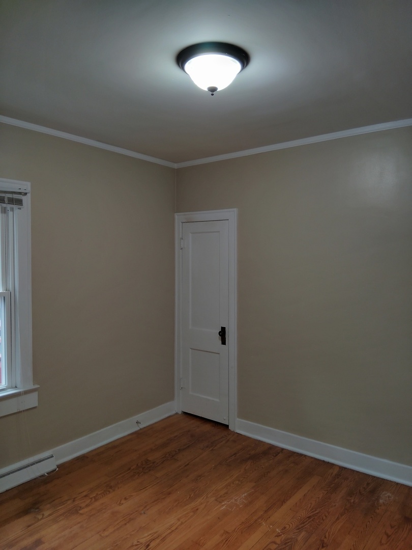 1406 Birch Road Homewood, IL 60430 - Photo 15 of 31 an empty room with wooden floor and windows