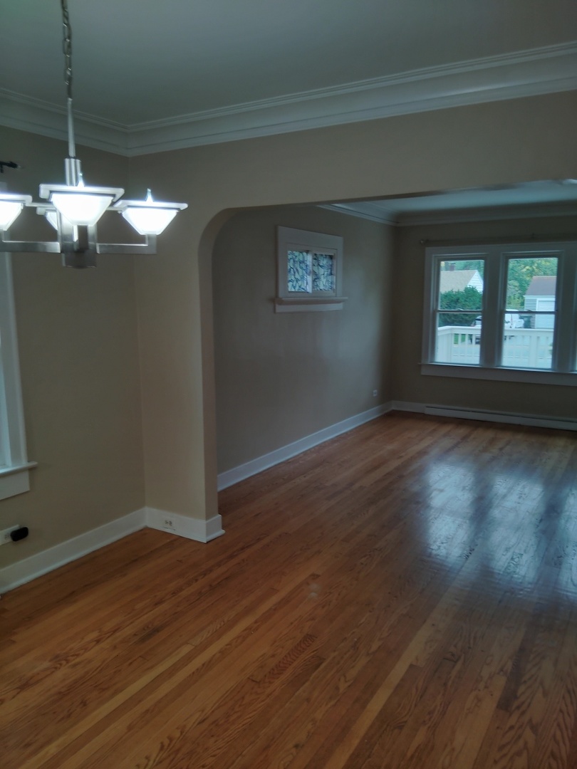 1406 Birch Road Homewood, IL 60430 - Photo 5 of 31 a view of a livingroom with wooden floor a ceiling fan and window