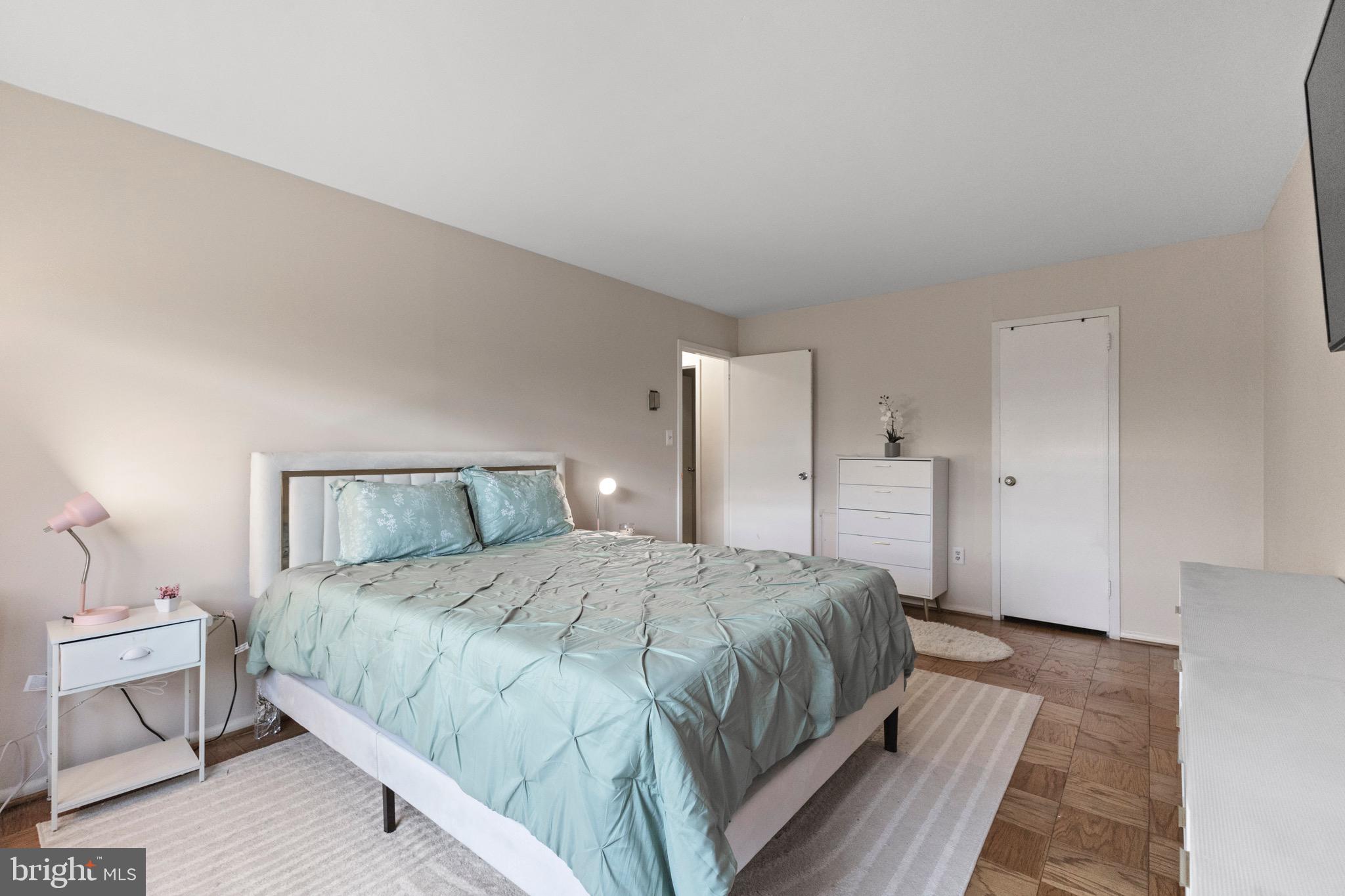 1111 University Boulevard West, Unit 313A Silver Spring, MD 20902 - Photo 9 of 20 a bedroom with a bed and a night stand