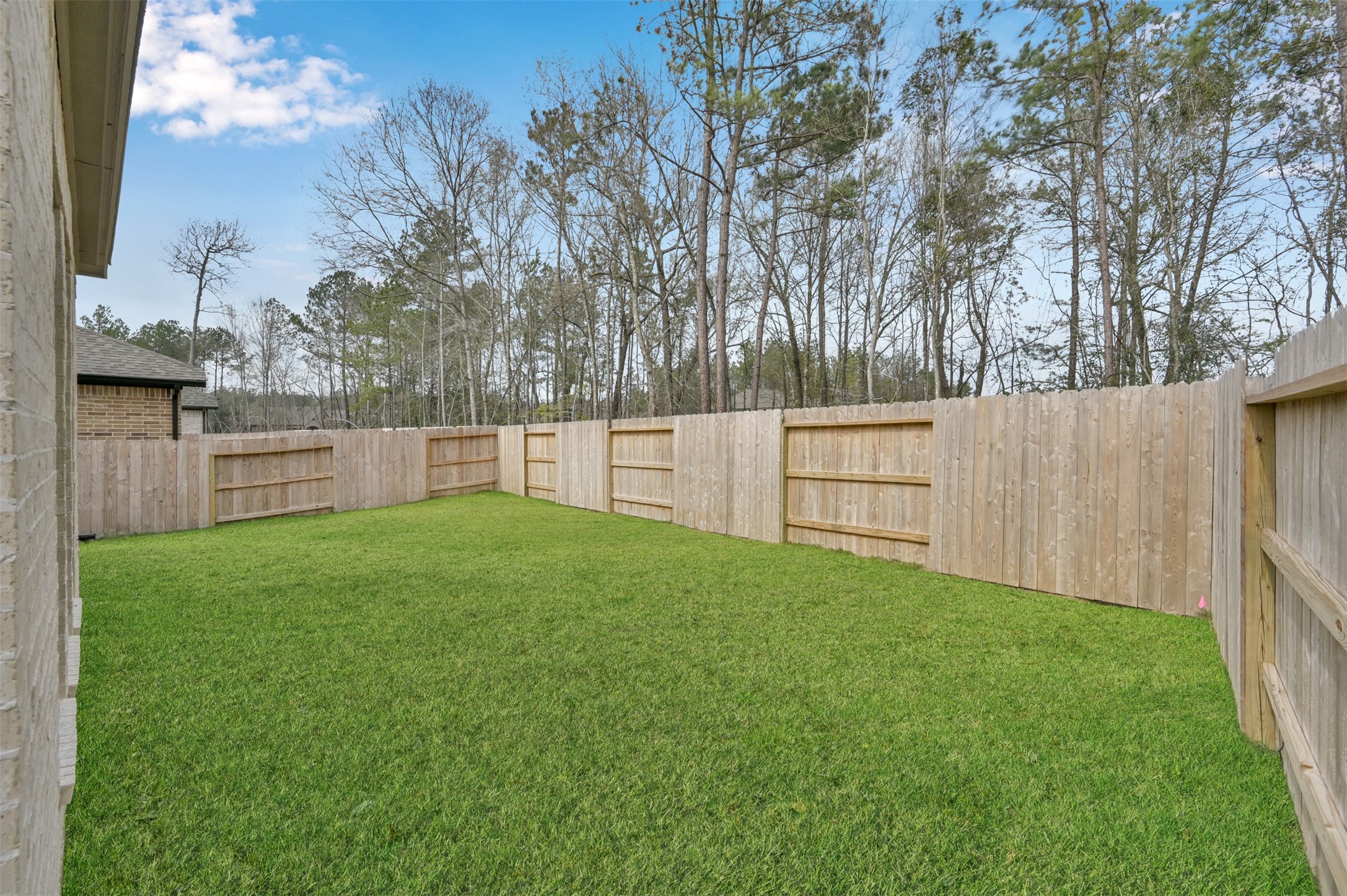 15715 Autumn Sun Conroe, TX 77302 - Photo 23 of 23 a view of a backyard with large trees and wooden fence