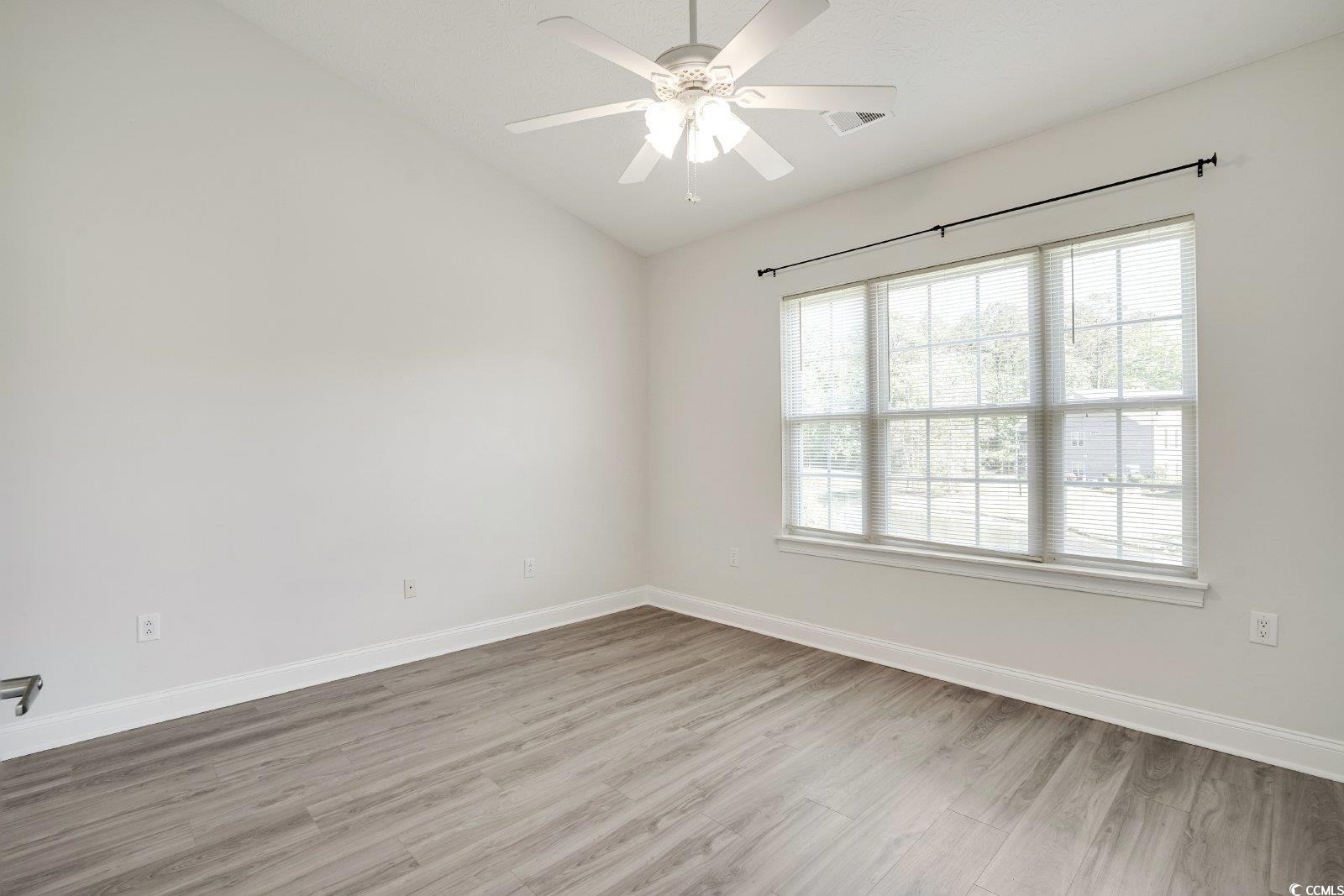 1113 Peace Pipe Place, Unit 204 Myrtle Beach, SC 29579 - Photo 11 of 27 Empty room with lofted ceiling, wood finished floors, and a ceiling fan