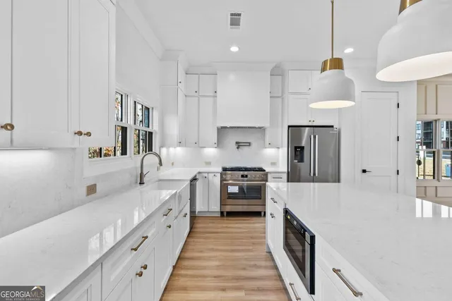 a kitchen with a sink dishwasher stove and white cabinets