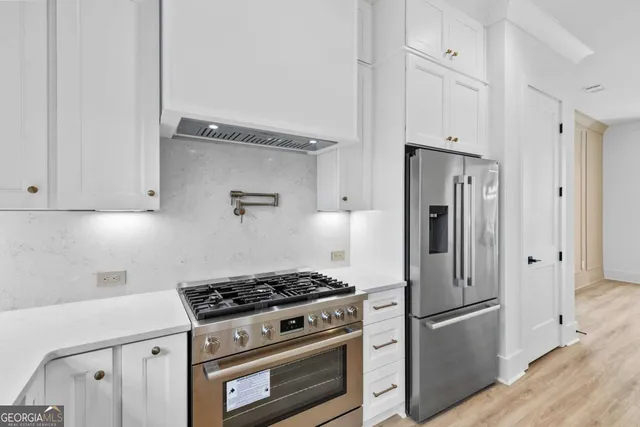 a kitchen with stainless steel appliances granite countertop a stove and cabinets
