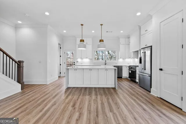 a large kitchen with stainless steel appliances granite countertop a lot of counter space and a refrigerator