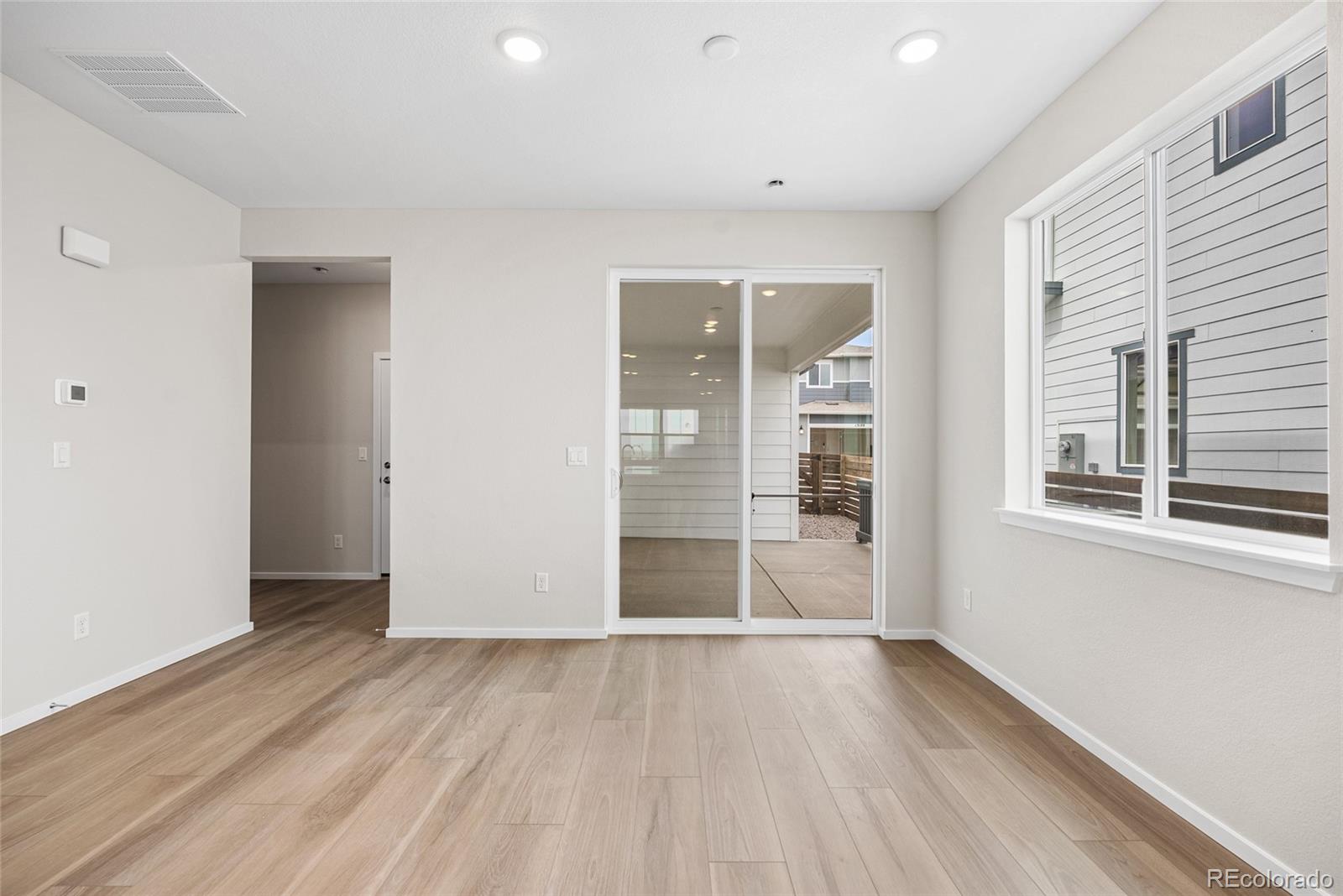 13181 Front Porch Lane Firestone, CO 80504 - Photo 13 of 34 an empty room with wooden floor and windows