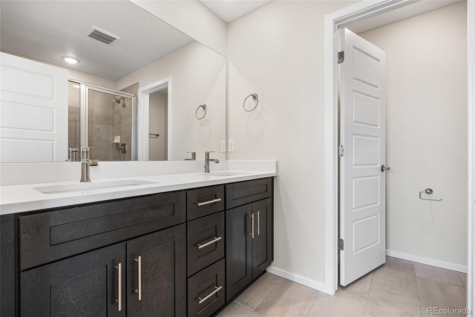 13181 Front Porch Lane Firestone, CO 80504 - Photo 15 of 34 a bathroom with a double vanity sink and mirror